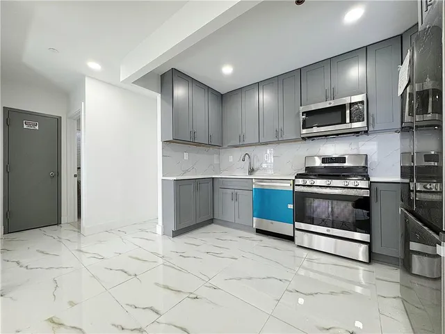 a kitchen with stainless steel appliances granite countertop a stove a sink and a refrigerator