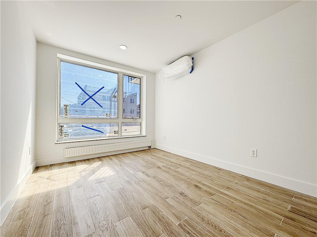 2819 West 17th Street, Unit 2B Brooklyn, NY 11224 - Photo 8 of 18 a view of an empty room with wooden floor and a window
