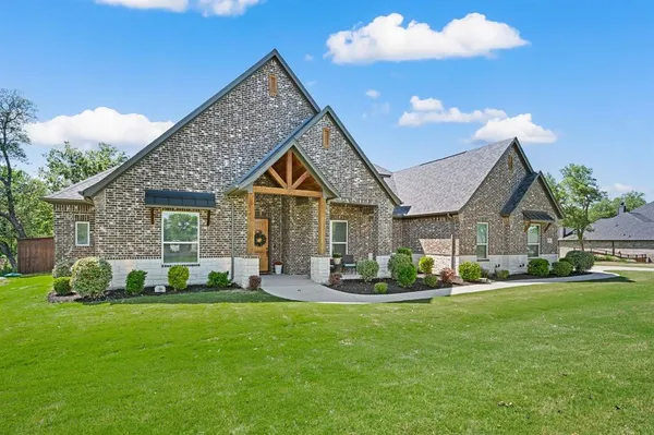 a front view of a house with a yard garden and outdoor seating