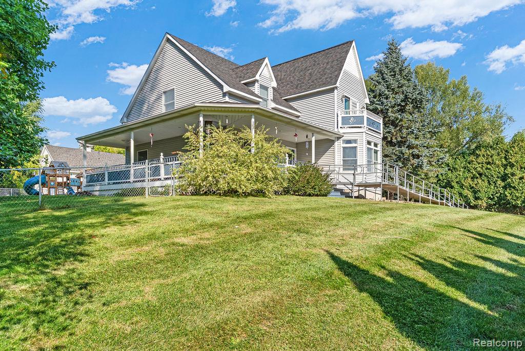 1476 County Farm Road Howell, MI 48843 - Photo 4 of 53 Rear view of property featuring a porch, a yard, and roof with shingles
