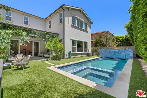 a view of a house with backyard and sitting area