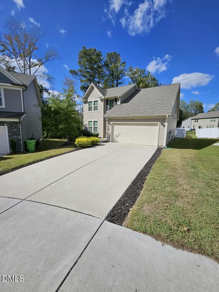 4305 Sir Julian Court Raleigh, NC 27610 - Photo 2 of 25 a front view of a house with a yard and garage