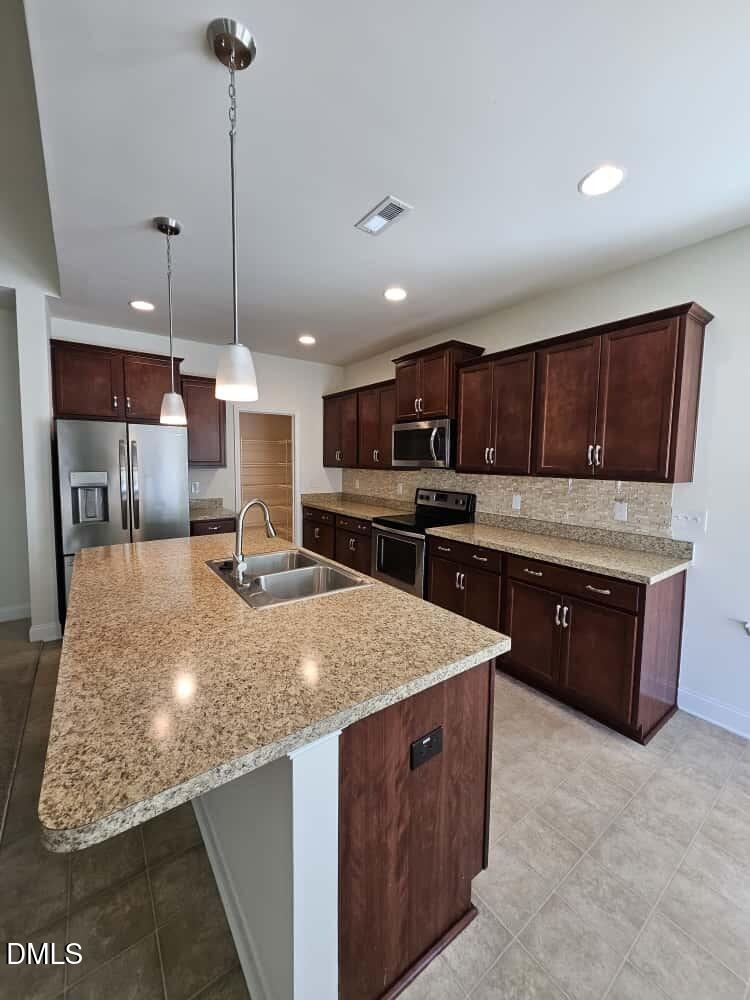 4305 Sir Julian Court Raleigh, NC 27610 - Photo 3 of 25 a large kitchen with kitchen island a sink stainless steel appliances and cabinets