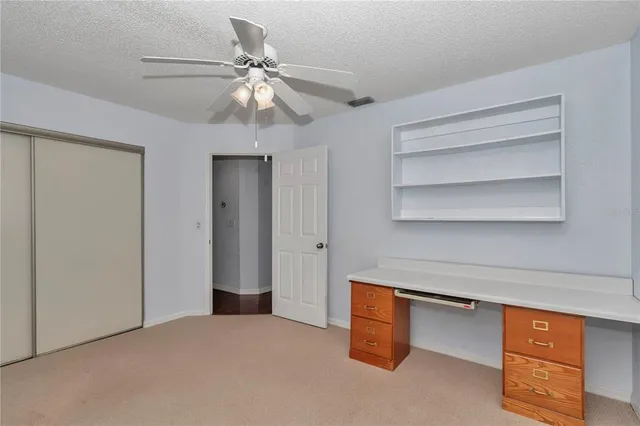 a room with closet and chandelier fan
