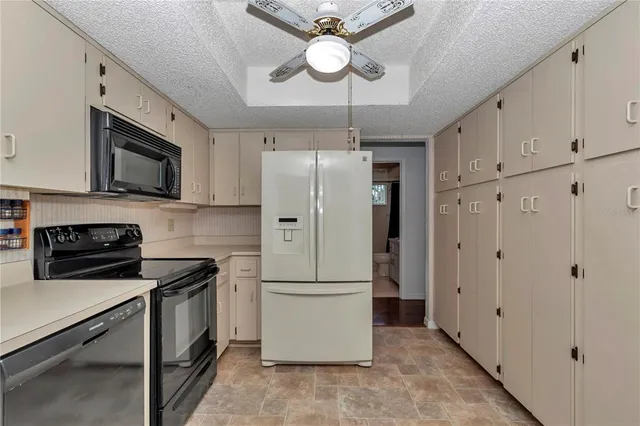 a kitchen with stainless steel appliances granite countertop a refrigerator a stove a microwave oven with white cabinets