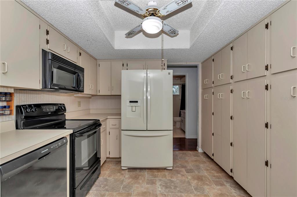 8012 Southwest 109th Place Road Ocala, FL 34481 - Photo 7 of 20 a kitchen with stainless steel appliances granite countertop a refrigerator a stove a microwave oven with white cabinets