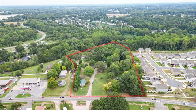 an aerial view of residential houses with outdoor space and trees