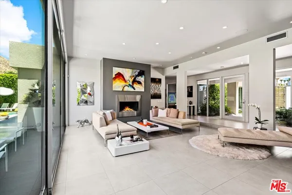 a living room with patio furniture and a floor to ceiling window