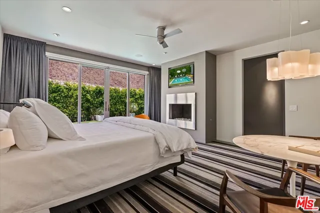 a bedroom with a bed lamp and a large window