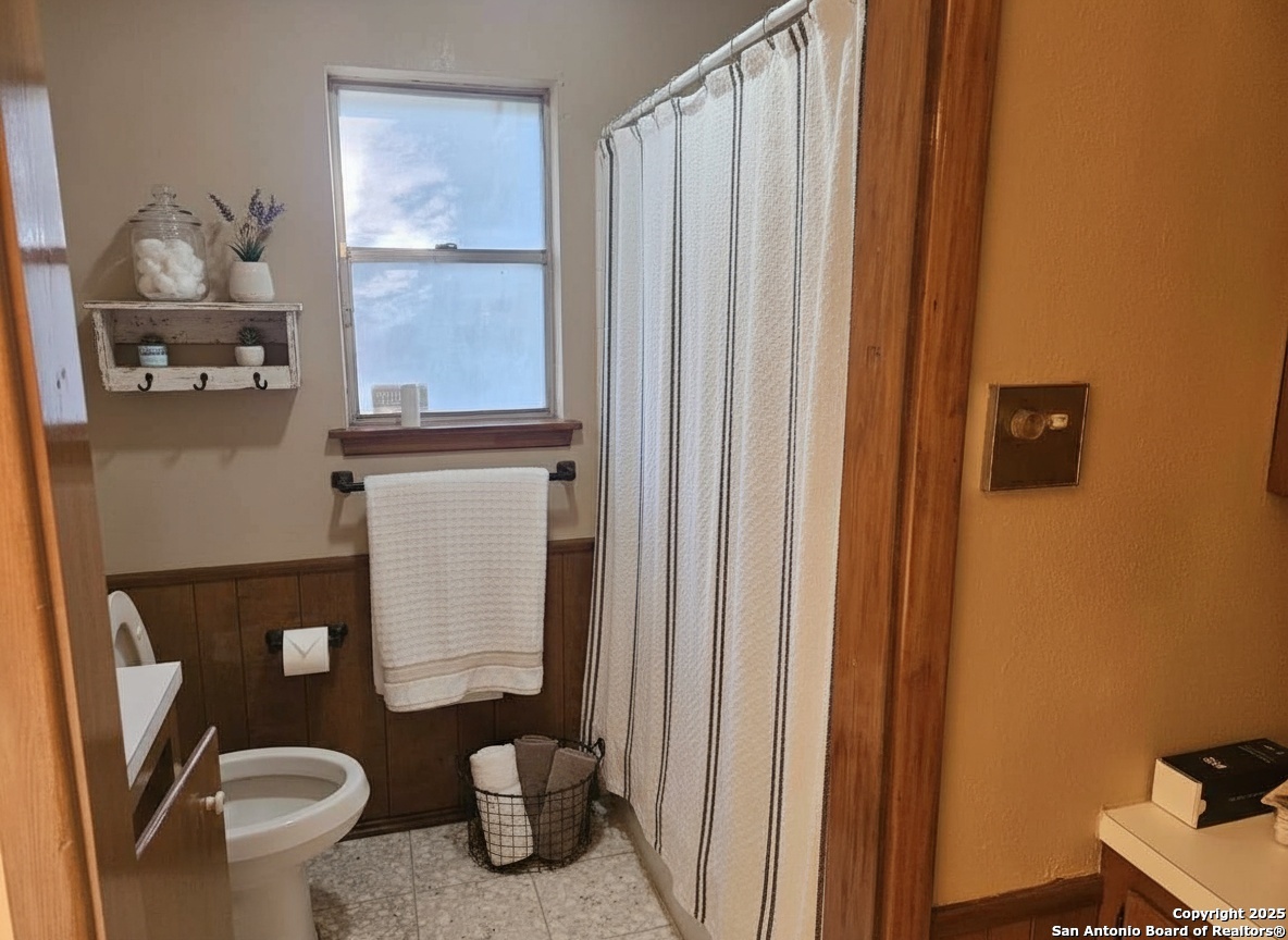 425 Golfcrest Drive Windcrest, TX 78239 - Photo 20 of 26 a bathroom with a toilet and a shower curtain