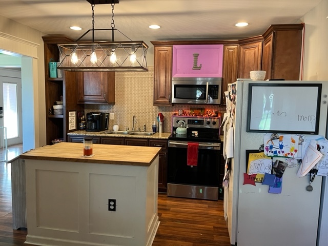 606 North 3rd Street Rochelle, IL 61068 - Photo 7 of 36 a kitchen with stainless steel appliances granite countertop a sink refrigerator stove and microwave