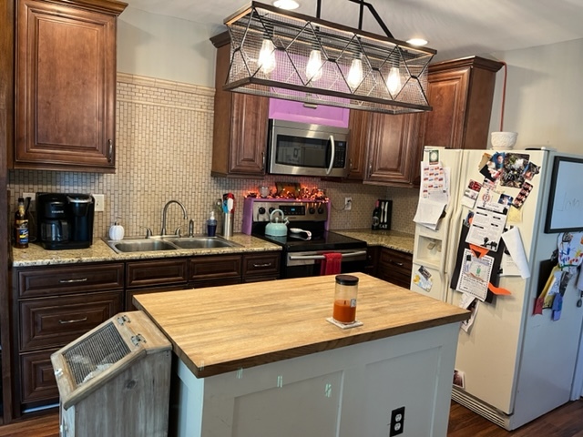 606 North 3rd Street Rochelle, IL 61068 - Photo 9 of 36 a kitchen with stainless steel appliances granite countertop a sink a stove and a wooden cabinets