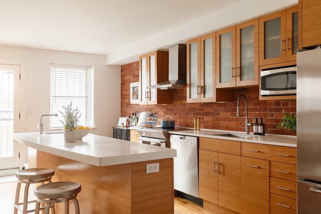 193 St Botolph Street, Unit 1 Boston, MA 02115 - Photo 2 of 15 a kitchen with stainless steel appliances granite countertop a sink stove and cabinets
