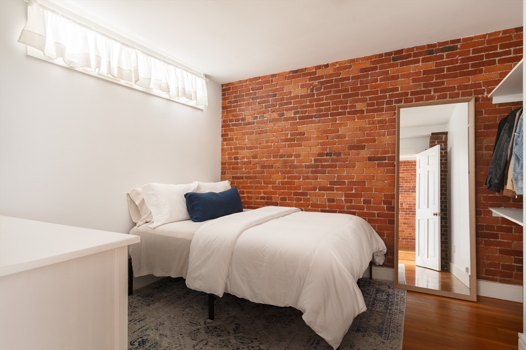 193 St Botolph Street, Unit 1 Boston, MA 02115 - Photo 8 of 15 a bedroom with a bed and wooden floor