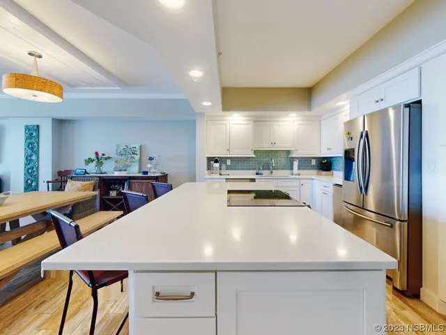 a kitchen with stainless steel appliances a table chairs and a refrigerator
