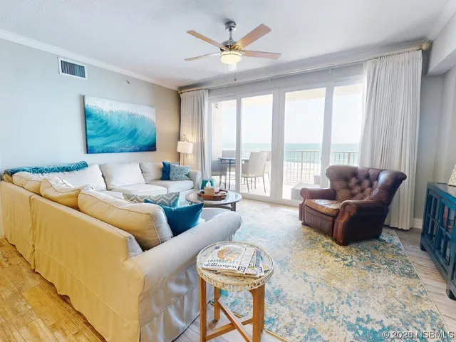 a living room with furniture and a large window with garden view