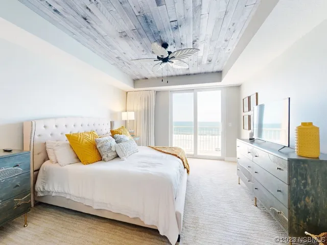 a spacious bedroom with a bed and a chandelier