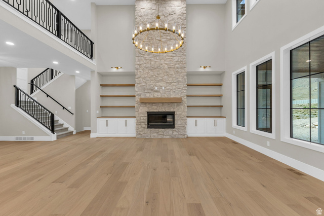 2828 Jojo Road Eagle Mountain, UT 84005 - Photo 8 of 63 Soaring ceilings featuring a stone fireplace with a wood mantle and built-in shelving