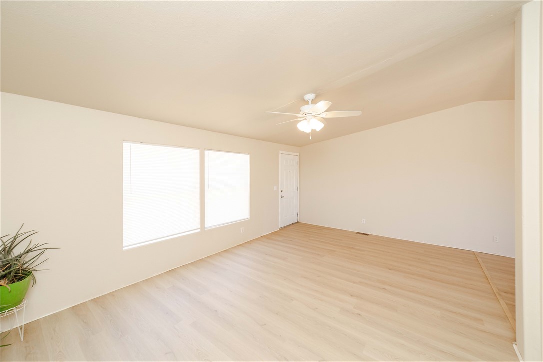 4729 Stewart Mountain Road Golden Valley, AZ 86413 - Photo 5 of 28 an empty room with wooden floor and windows