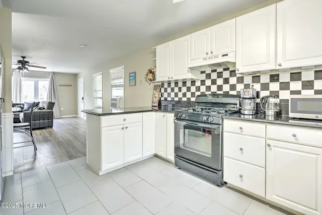 a kitchen with granite countertop white cabinets and white appliances
