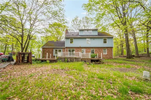 a view of a house with a big yard and large trees