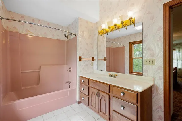 a bathroom with a tub a sink and a mirror