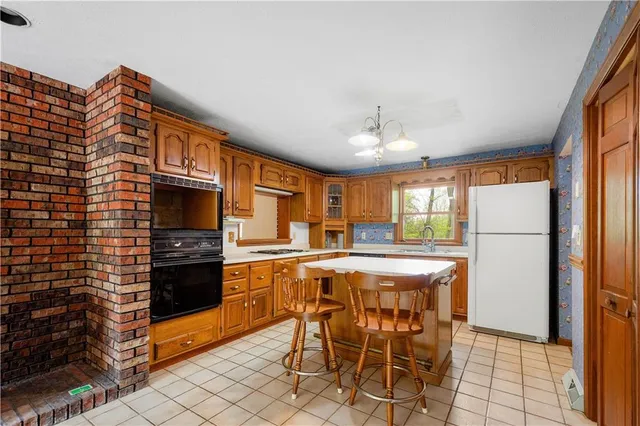 a kitchen with stainless steel appliances granite countertop a stove top oven a sink a dining table and chairs