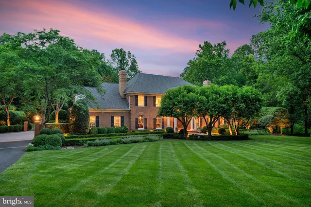 a front view of a house with a yard and trees