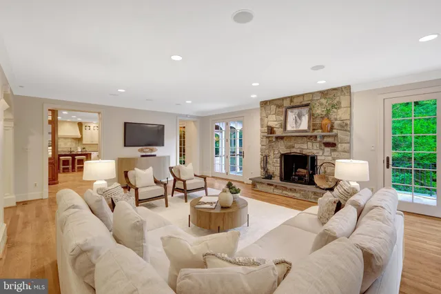 a living room with furniture a fireplace and a large window