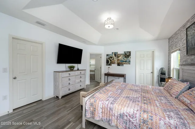 a bedroom with a bed and a flat screen tv