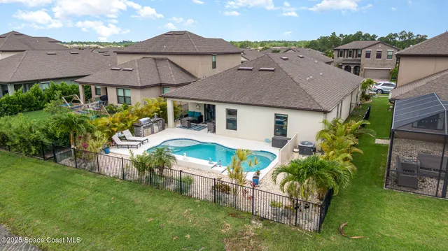an aerial view of a house with swimming pool garden and patio