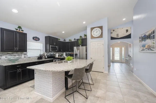 a kitchen with stainless steel appliances granite countertop a sink a stove and cabinets