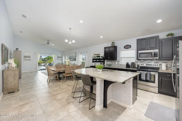 a view of kitchen with microwave stove dining table and chairs