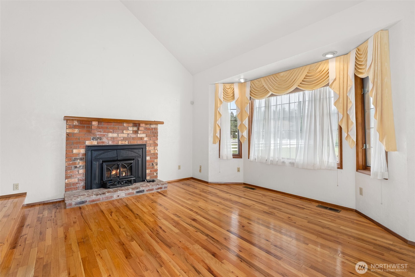141 East Deer Creek Road Shelton, WA 98584 - Photo 7 of 40 a view of an empty room with wooden floor fireplace and a window