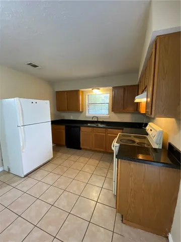 a kitchen with granite countertop a sink and a stove top oven