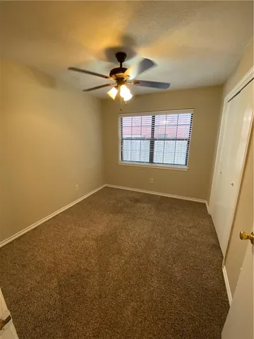 en empty room with windows and fan