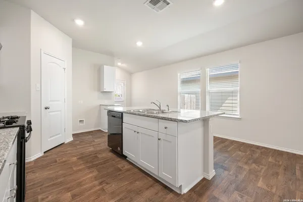 a kitchen with granite countertop white cabinets and white appliances
