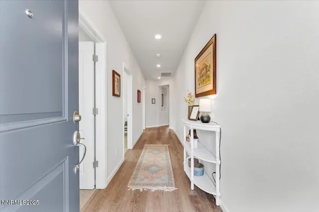 a living room with stainless steel appliances granite countertop furniture sink and wooden floor