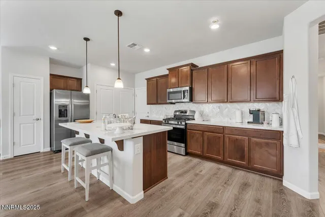 a kitchen with stainless steel appliances granite countertop a sink a stove and a refrigerator