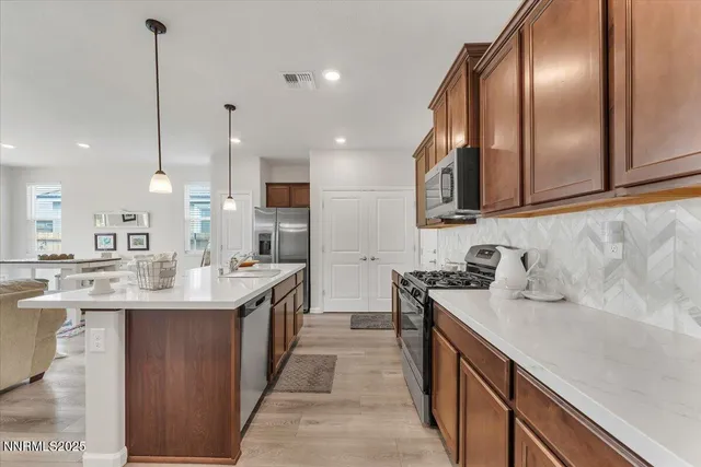 a kitchen with a refrigerator a stove top oven a sink dishwasher and white cabinets with wooden floor