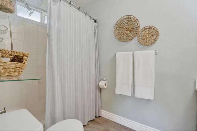 a bathroom with a toilet and a shower curtain