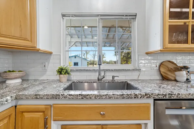 a kitchen with granite countertop a sink and a window