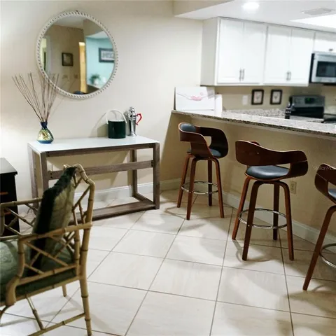 a kitchen with stainless steel appliances kitchen island a table chairs in it and wooden floor