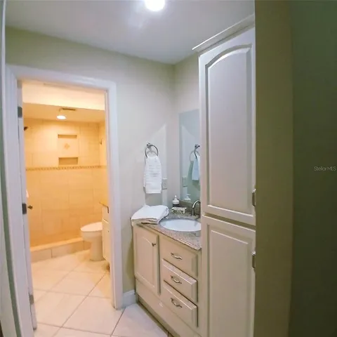 a bathroom with a granite countertop sink a mirror and a shower