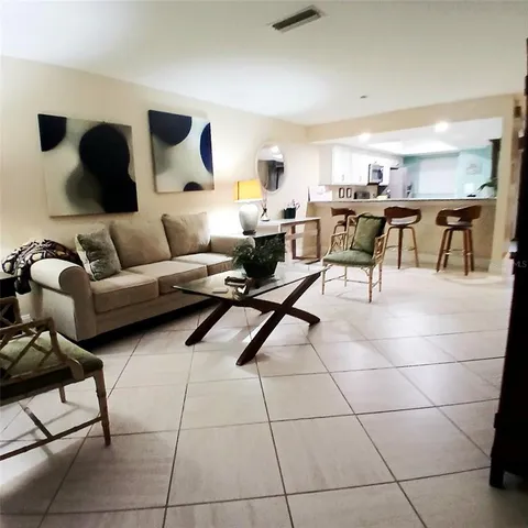 a living room with furniture and kitchen view