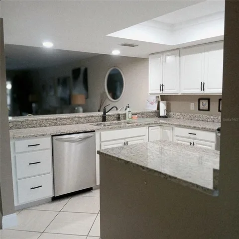 a kitchen with granite countertop a sink and a stove
