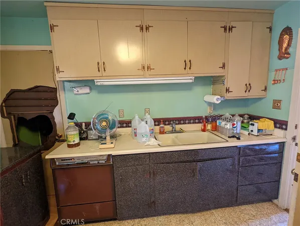 a kitchen with kitchen island granite countertop a sink a stove and cabinets