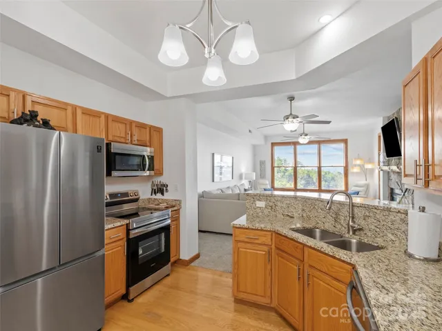 a large kitchen with granite countertop a stove refrigerator and microwave