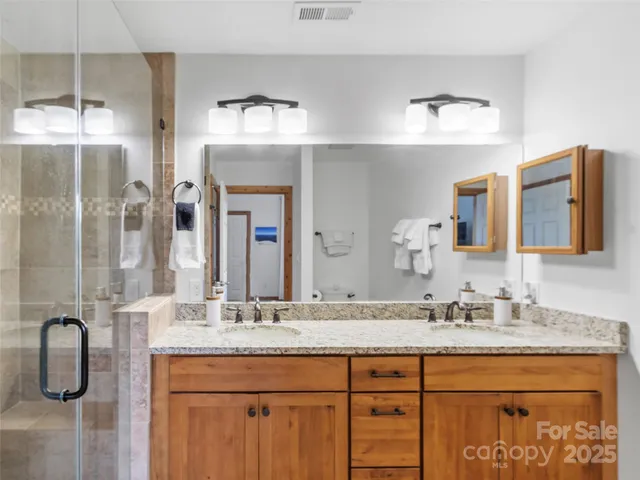 a bathroom with a granite countertop sink a large mirror and vanity