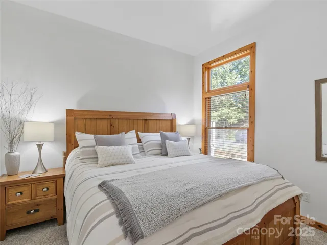 a bedroom with a bed and a lamp next to a window